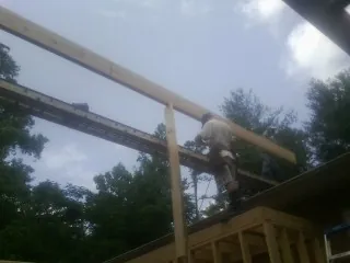Carpenter setting a ridge beam over a new addition frame — Ice Dam Removal by Roofing Brothers in Cohoes