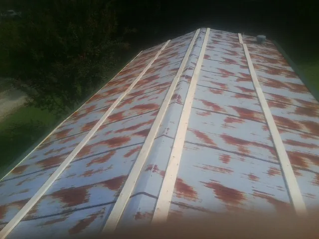 Rusted metal roof panels with new wood purlins before replacement — Storm Damage Roof Repair in Cohoes by Roofing Brothers