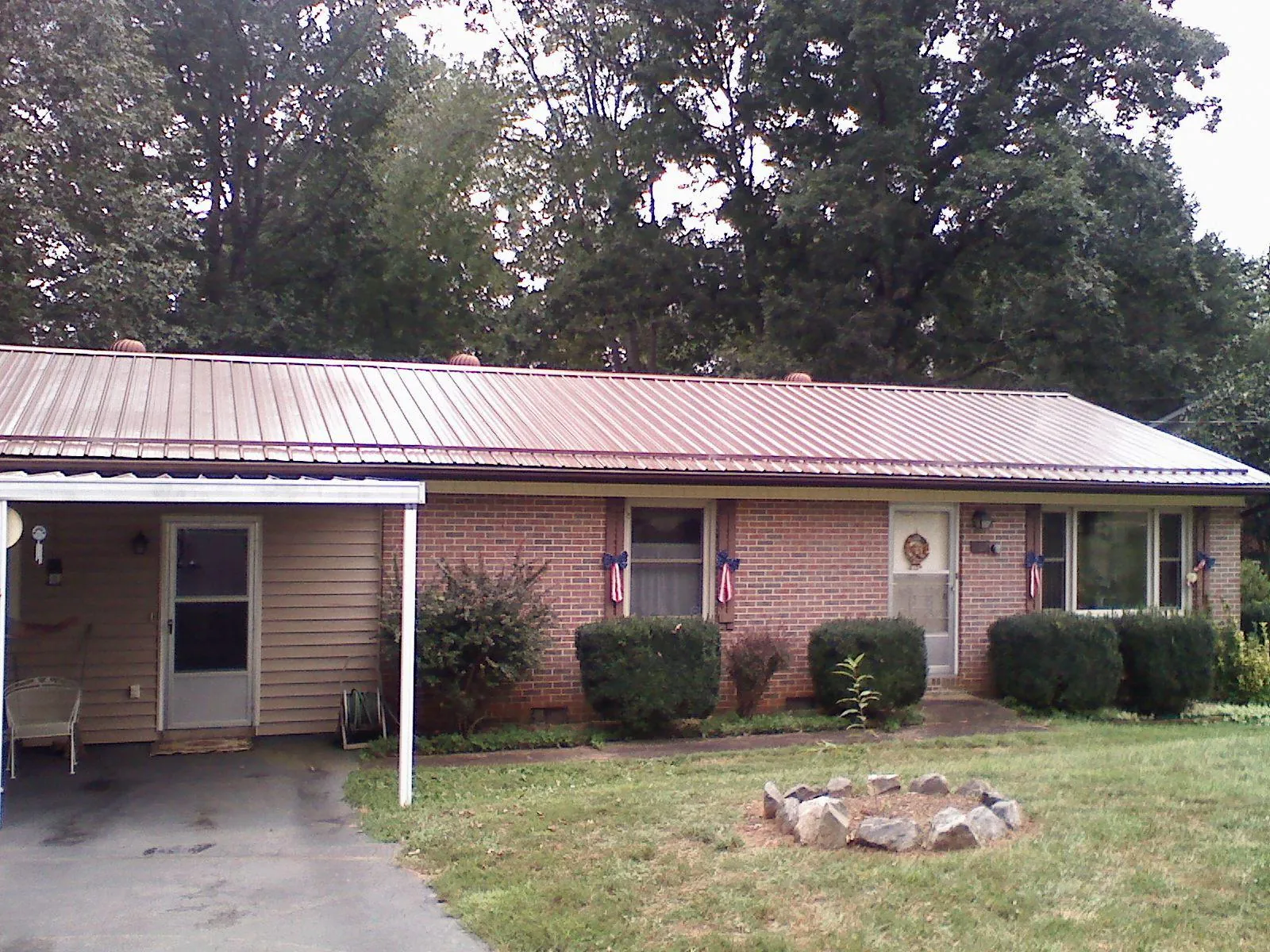 Bronze metal roof and carport on a brick ranch home — Roof Repair work by our crew in Cohoes